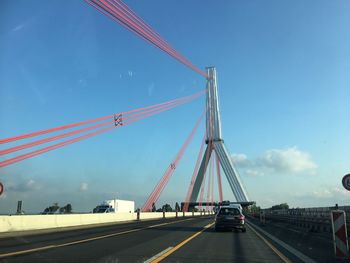 View of suspension bridge against blue sky