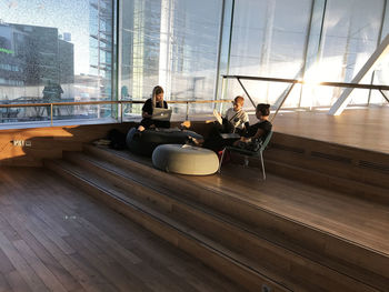 People sitting on glass window in city