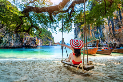 Rear view of woman sitting on slide at beach