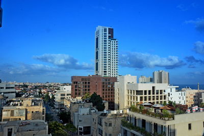 Buildings in city against blue sky