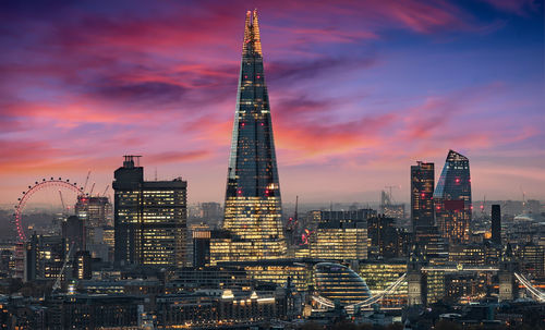 Illuminated cityscape against sky during sunset