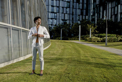 Full length of man standing against glass wall