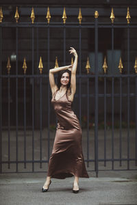 Full length of young woman standing against wall