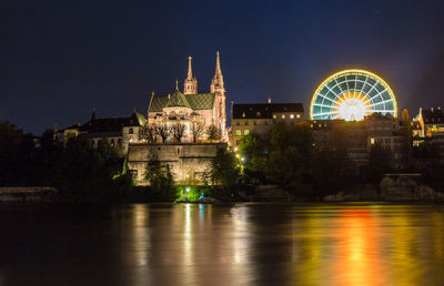 Illuminated ferris wheel in city at night