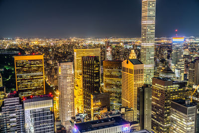 Illuminated cityscape against sky at night