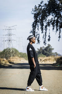 Side view of man wearing hat against sky