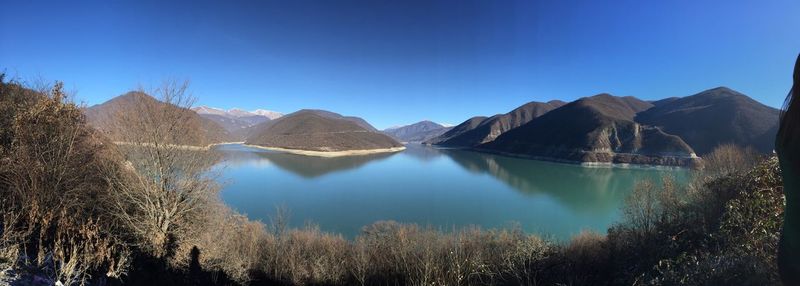 Panoramic view of lake and mountains against clear blue sky