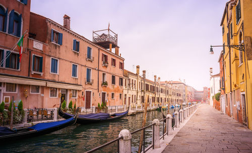 Gondolas moored on grand canal amidst buildings in city