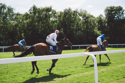 Men riding horses on field