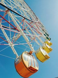 Low angle view of ferris wheel against blue sky