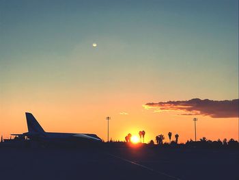 Silhouette airplane against sky during sunset