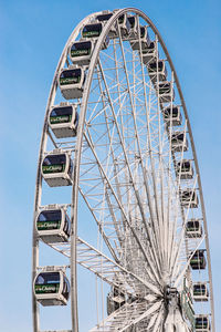 Low angle view of ferris wheel against blue sky