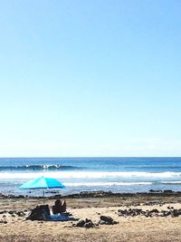 Scenic view of beach against blue sky