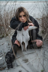 Portrait of a young woman sitting outdoors