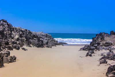 Scenic view of beach against clear blue sky