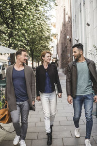 Young couple walking on footpath in city