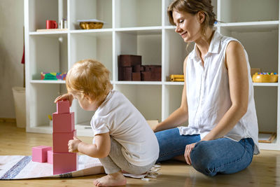 Smiling mother playing with daughter at home