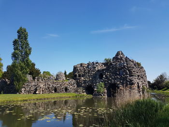 Old ruin by plants against sky