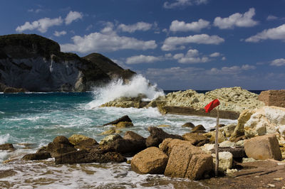 Scenic view of rocks on beach against sky