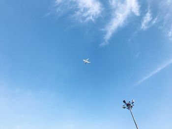 Low angle view of airplane flying against blue sky