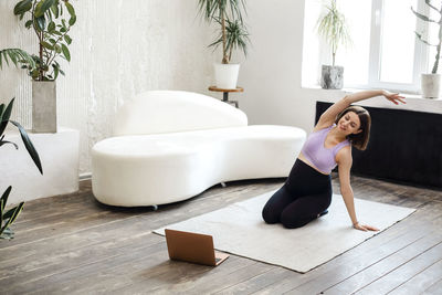 Full length of woman exercising at home