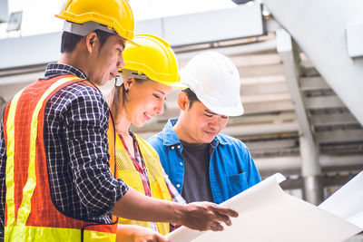 Low angle view of men working at construction site