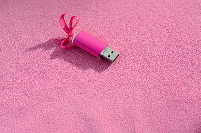 Close-up of usb stick on pink fabric
