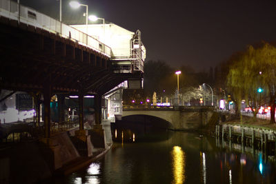 Illuminated bridge over river at night
