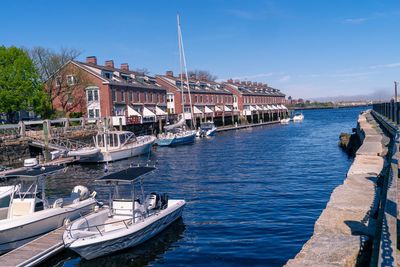 Sailboats moored at harbor against sky