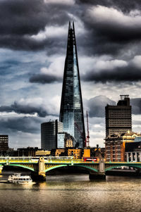 Low angle view of bridge over river against cloudy sky