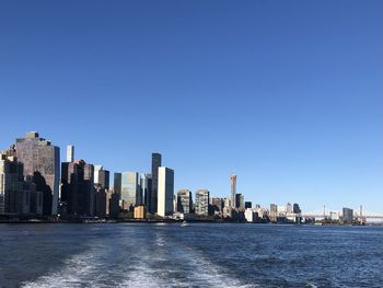 Modern buildings in city against clear blue sky