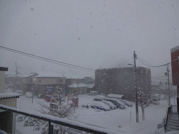 Snow covered street amidst buildings in city