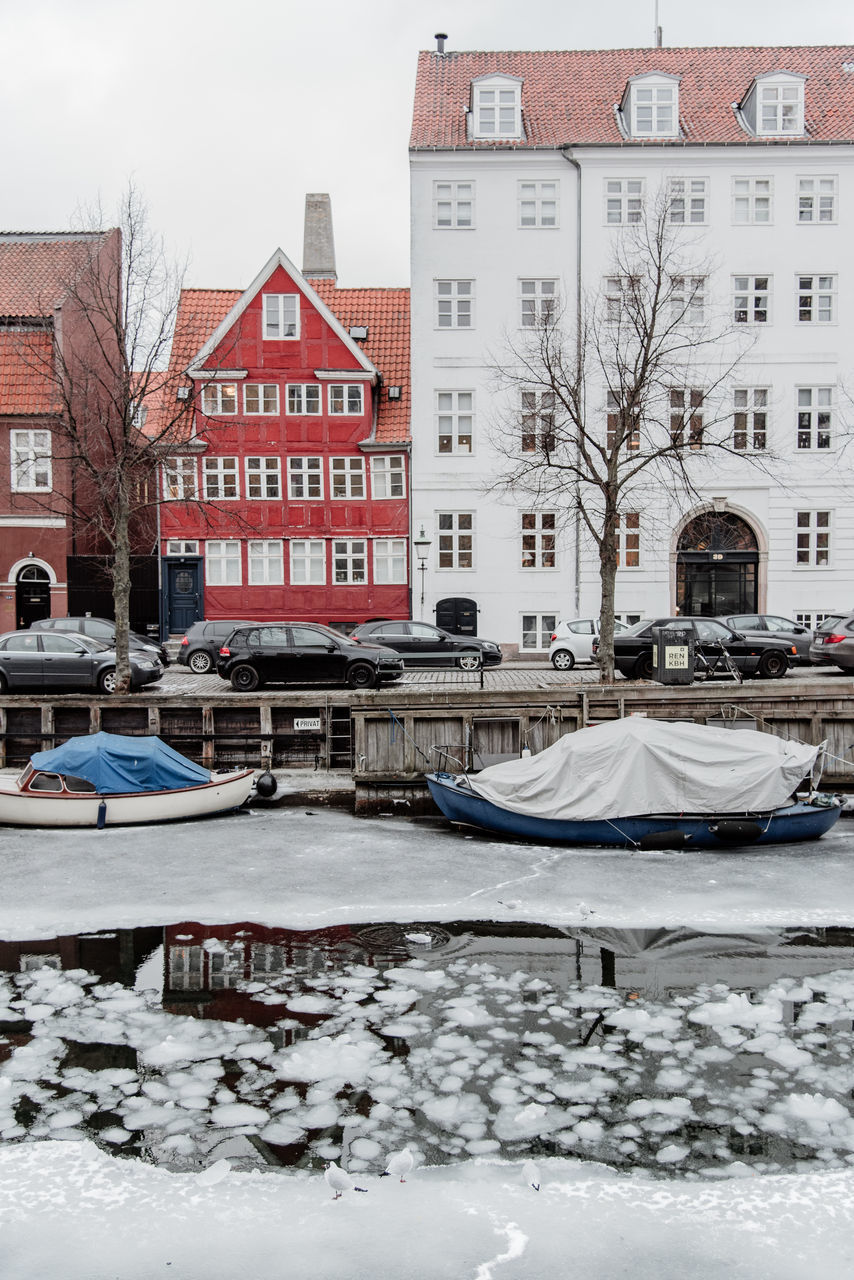 BOATS MOORED IN CANAL BY BUILDINGS IN CITY