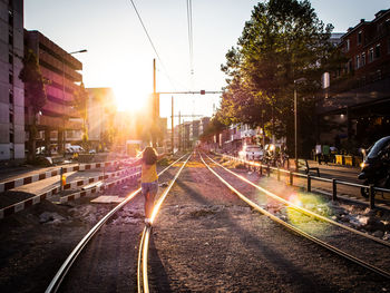 Rear view full length of woman on railroad track against sky in city