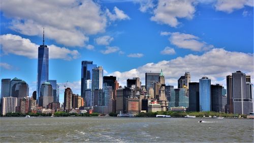 Modern buildings in city against cloudy sky