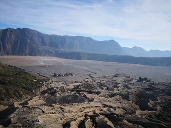 Scenic view of land and mountains against sky