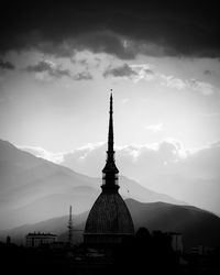 Silhouette of temple against cloudy sky