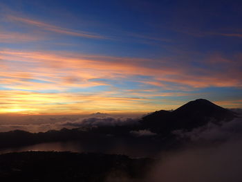 Scenic view of silhouette mountains against sky at sunset