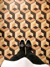 Low section of person standing on tiled floor