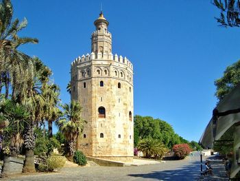 Low angle view of tower of gold against clear blue sky