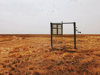 Lifeguard hut on field against sky