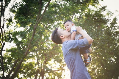 Father and son against trees