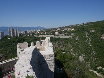 Panoramic view of buildings in city against clear blue sky