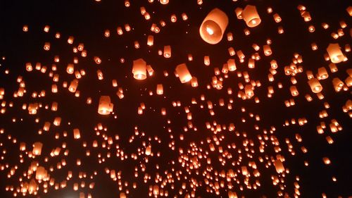 Low angle view of illuminated lantern against sky at night