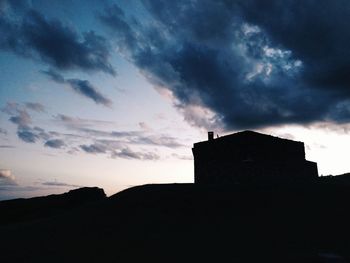 Silhouette buildings against sky at sunset