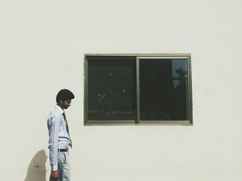 Side view of businessman walking by building