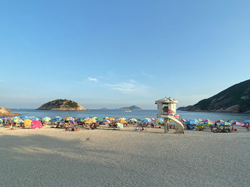 Group of people on beach against sky