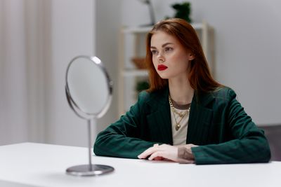 Portrait of young woman sitting on table