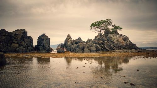 Rock formations in sea against sky