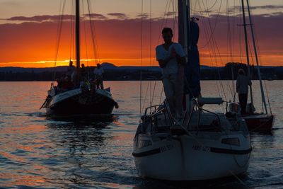 Boat sailing in sea against sky during sunset